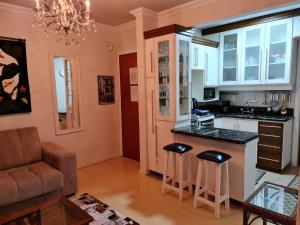 cocina con encimera y taburetes en una habitación en Conheça Gramado no Montebello, en Gramado