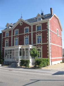 a large red brick building on the side of a street at L'auberge in Baronville