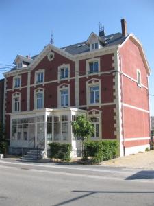 un gran edificio de ladrillo rojo en el lateral de una calle en L'auberge, en Baronville