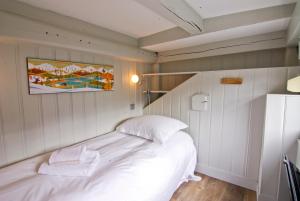 - une chambre avec un lit blanc et une peinture murale dans l'établissement Appartement Bellevue - centre ville, à Chamonix-Mont-Blanc