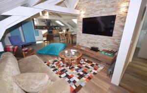 - un salon avec un canapé et une télévision sur un mur en briques dans l'établissement Appartement Bellevue - centre ville, à Chamonix-Mont-Blanc