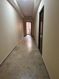 an empty hallway with a door and a tile floor at Alex in Yerevan