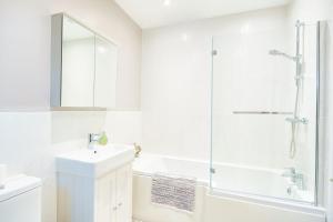 a white bathroom with a sink and a shower at Ty Bledrws - family retreat near the Cardigan Bay coast 