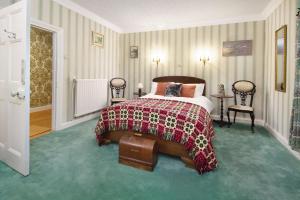 1 dormitorio con 1 cama con manta roja y negra en Ty Bledrws - family retreat near the Cardigan Bay coast, 