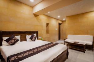 a bedroom with a bed and a bench in it at Hotel Akashdeep - Located City Centre in Jaisalmer