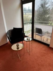 een kamer met een stoel, een tafel en een raam bij Pension COLUMBIA inkl. Frühstück im Zentraum in Bad Gleichenberg