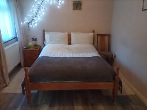 a bedroom with a bed with lights on the wall at The Annex - Guest Gardens in Milton Keynes
