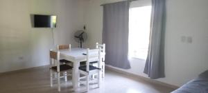 una mesa y sillas blancas en una habitación con ventana en Vista andes II en Luján de Cuyo