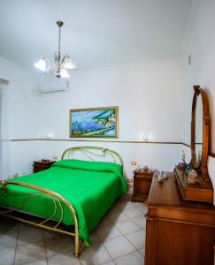 a bedroom with a green bed and a desk at Sole Holiday House in Pontone