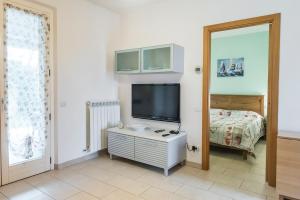 een woonkamer met een tv en een bed bij M329 - Marcelli, bilocale con giardino e garage in Marcelli