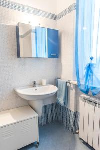 een badkamer met een wastafel en een blauw douchegordijn bij M329 - Marcelli, bilocale con giardino e garage in Marcelli