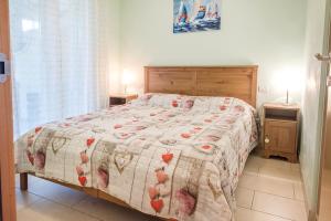 een slaapkamer met een bed met een quilt met harten erop bij M329 - Marcelli, bilocale con giardino e garage in Marcelli