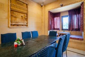 a conference room with a table and blue chairs at Hotel Akashdeep - Located City Centre in Jaisalmer