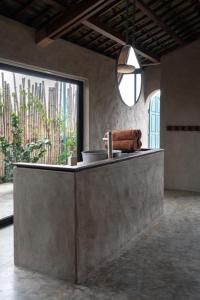 a concrete counter in a room with a large window at Dechiu in Hoi An
