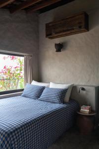 a bedroom with a blue and white bed with a window at Dechiu in Hoi An