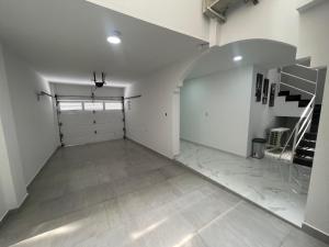 eine leere Garage mit einer Treppe und weißen Wänden in der Unterkunft PARK 83 Apartaestudios in Cali