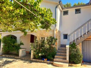 une maison blanche avec des escaliers en face de celle-ci dans l'établissement villa.sunny.nin, à Nin