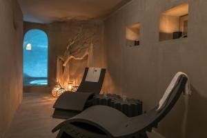 a living room with a dinosaur chair and a table at Sifnos House - Rooms and SPA in Kamarai