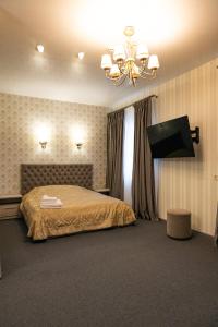 a bedroom with a bed and a chandelier at Готель Otelnov in Poltava