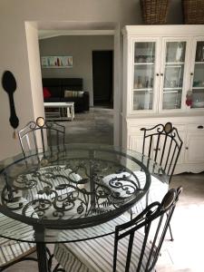 una mesa de cristal y sillas en la sala de estar. en Gîte La Sellerie en Les Sorinières