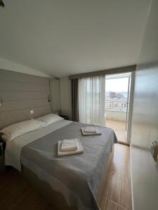 1 dormitorio con 1 cama con 2 toallas en Apartments Villa Simoni en Split