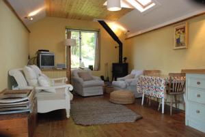 a living room with white furniture and a tv at The Long Barn in Skibbereen