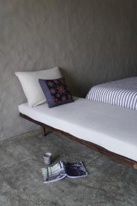 a bed with a pillow and a pair of shoes on the floor at Dechiu in Hoi An