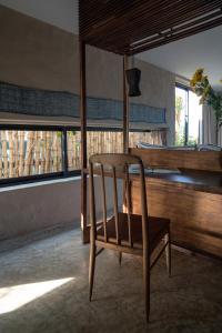 a wooden chair in a room with windows at Dechiu in Hoi An