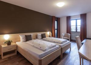 Habitación de hotel con 2 camas y mesa en Brauereigasthof Hofmark, en Lenting