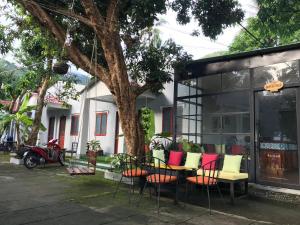 a group of chairs and tables in front of a building at Eden House & Coffee Con Dao in Con Dao