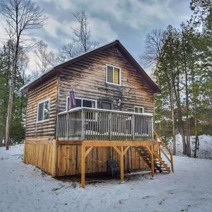 Cabaña de madera con terraza en la nieve en Juniper Cabin- Waterfront retreat on Mosque Lake, en Ompah