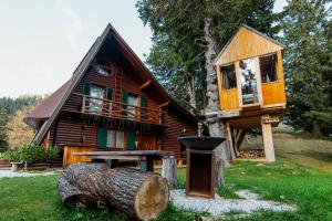 une cabane dans les arbres avec un grill en face de celle-ci dans l'établissement Tree House Alpinka Krvavec, à Cerklje na Gorenjskem