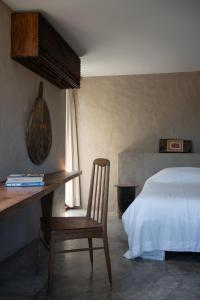 a bedroom with a bed and a wooden desk and a chair at Dechiu in Hoi An