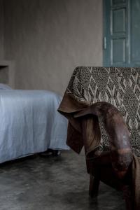 a chair with a blanket on top of it next to a bed at Dechiu in Hoi An