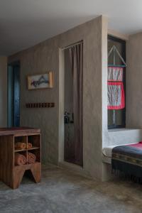 a bathroom with a shower and a bed and a table at Dechiu in Hoi An