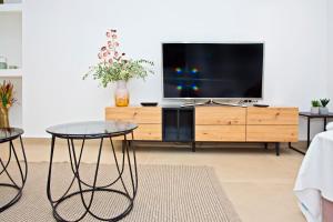 sala de estar con TV en un centro de entretenimiento de madera en Flowers Premium Apartments & Rooms, en Zagreb