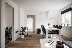 a white living room with a table and chairs at the Little Oasis In Gothenburg in Gothenburg