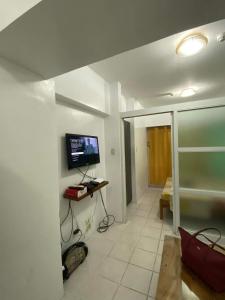 CATHELINE STAYCATION في تاجيتاي: غرفة معيشة مع تلفزيون على الحائط