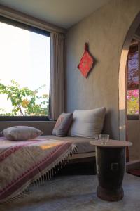 a bed in a room with a window and a table at Dechiu in Hoi An