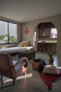 a bedroom with a bed and a couch and a chair at Dechiu in Hoi An