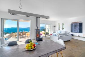 a living room with a table with a bowl of fruit at Villa Thalia Floating Heaven in Porto Heli