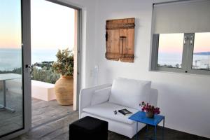 a living room with a white couch and a table at Villa Thalia Floating Heaven in Porto Heli