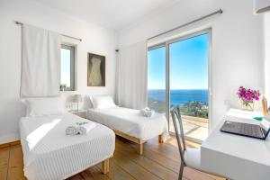 a white room with two beds and a window at Villa Thalia Floating Heaven in Porto Heli