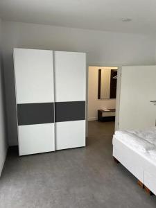 シェーネベックにあるFerienhof Elbaueのベッドルーム1室(ベッド1台、白と黒のキャビネット付)