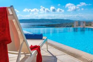 a chair sitting next to a swimming pool at Villa Thalia Floating Heaven in Porto Heli