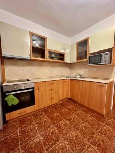a kitchen with wooden cabinets and a stove and microwave at Ruski Boulevard in Plovdiv