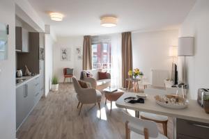 a kitchen and living room with a table and chairs at Domitys Le Domaine d'Agate in Soissons