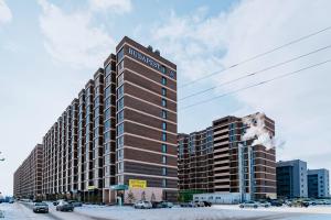 un edificio alto en una calle de la ciudad con coches en Аэропорт 10 минут, en Astana