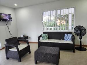 sala de estar con sofá, silla y ventana en Red Snapper Guest House, en Providencia