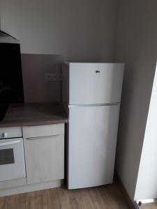 um frigorífico branco numa cozinha ao lado de um fogão em Gardon em Remoulins